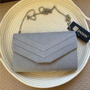 New with tags gray/silver evening clutch. Has the chain to wear over shoulder.